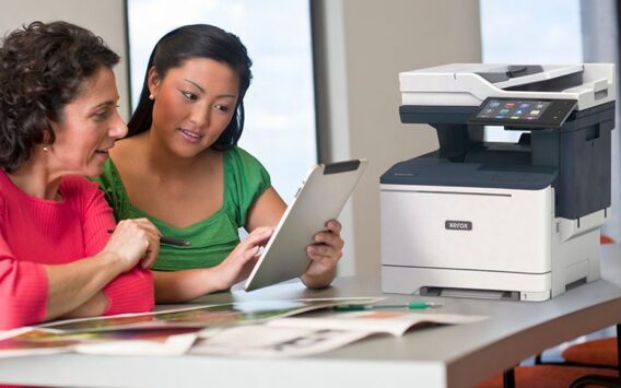Deux femmes utilisent une tablette avec une imprimante multifonction Xerox® VersaLink B415