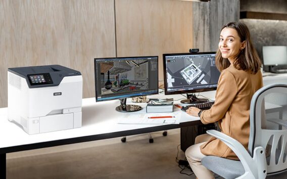 Une femme dans un bureau, à côté de l'imprimante Xerox® VersaLink® C620