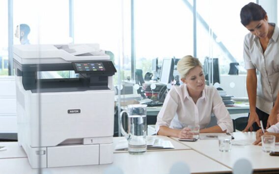 Deux femmes travaillant dans un bureau à côté d'une imprimante multifonction couleur Xerox® VersaLink® C625